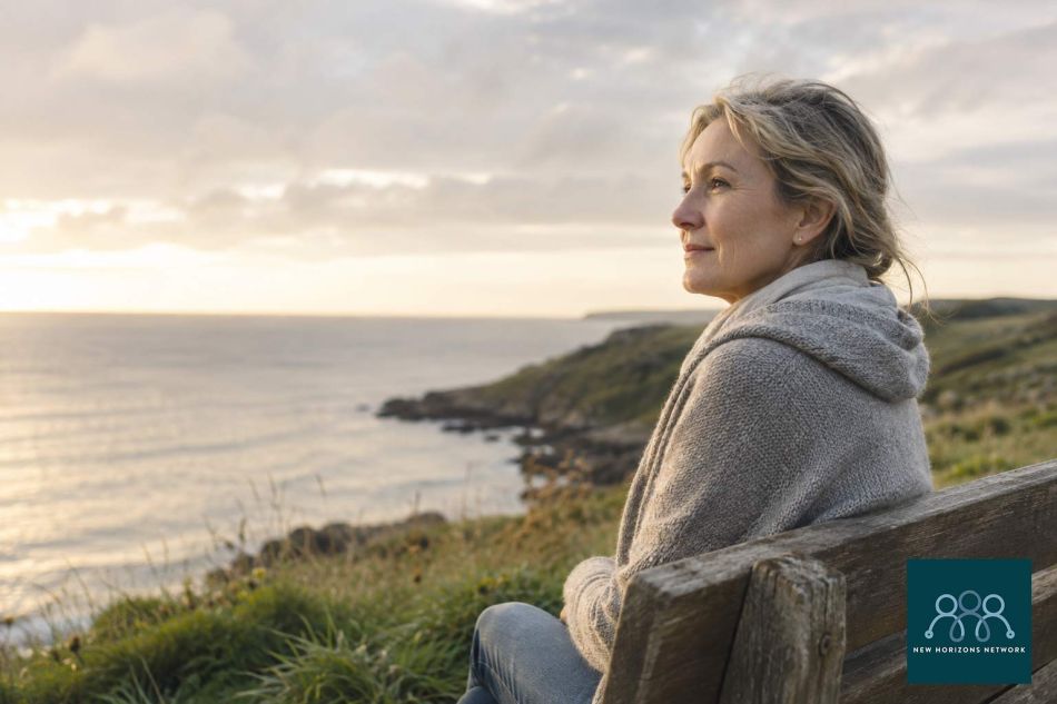 Person sitting peacefully by the coast reflecting, representing grief and the process of healing